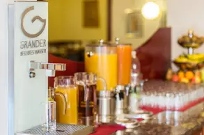 Auswahl an verschiedenen Fruchtsäften in Glaskaraffen auf einer gekühlten Station am Buffet.
