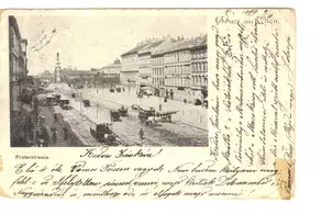 Historische Postkarte von der Praterstraße in Wien, circa 1899. Die Ansicht zeigt eine breite Straße mit Pferdefuhrwerken sowie Gebäuden beiderseits. In der Mitte steht ein Denkmal, im Hintergrund sind weitere Gebäude sichtbar. Handgeschriebene Notizen sind am rechten Rand sichtbar.
